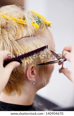 woman having her hair tips cut in salon