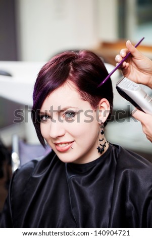 Portrait of young woman having haircut in salon