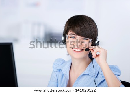 Happy female customer service representative working with headphone and computer