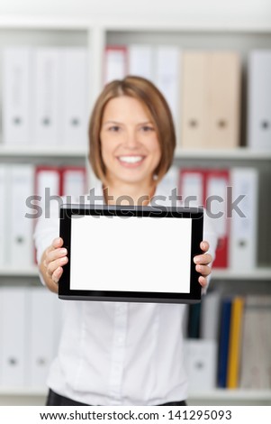 Smiling secretary showing a digital tablet over the office files background