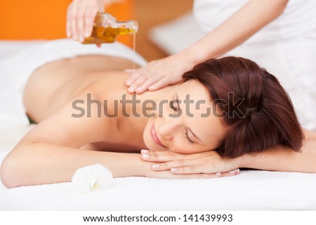 Beautiful young woman enjoying a spa beauty treatment with an oil based massage
