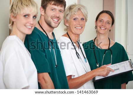 Portrait of happy male and female doctors standing in hospital