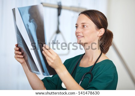 Portrait of female doctor holding hip Xray report in hospital