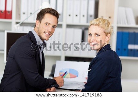 Portrait of a young businessman and woman in meeting at office desk