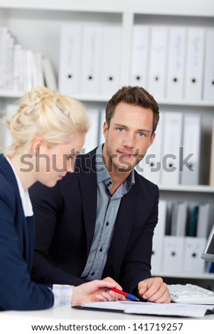 Young businessman and woman in meeting at office desk