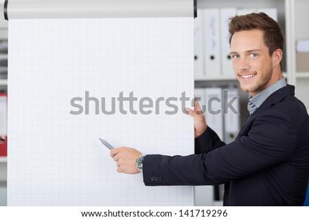 Portrait of a young businessman showing free text space on flipchart