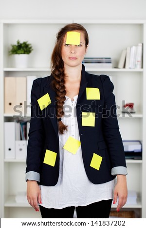 Beautiful Caucasian businesswoman standing in the office with post it notes on her body