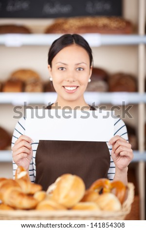 young woman at bakery counter displaying blank paper
