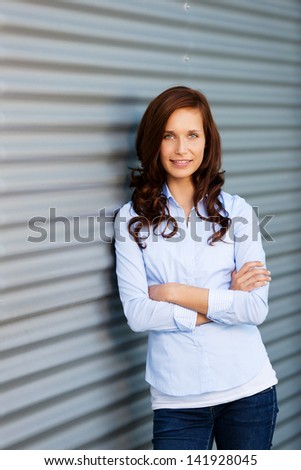 Woman posing with arms crossed and leaning on a rolling door