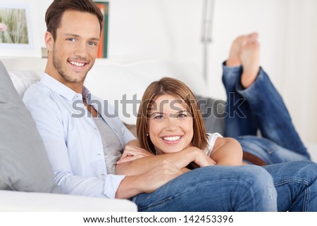 Beautiful smiling couple relaxing in sofa at home