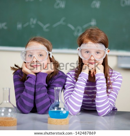 Two beautiful students learn about chemistry inside the classroom