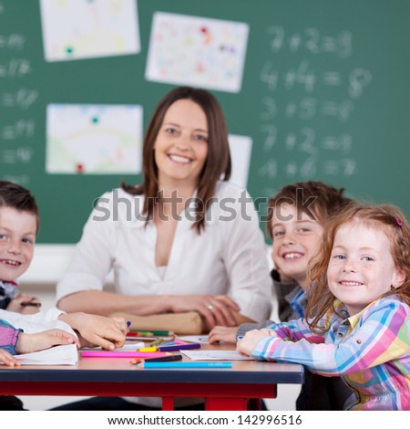 Teacher in classroom with his little happy students in the classroom