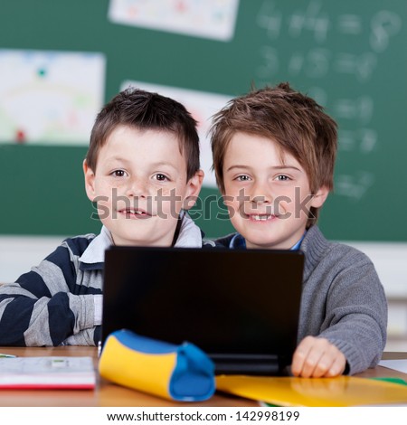 Elementary students working with laptop at the classroom