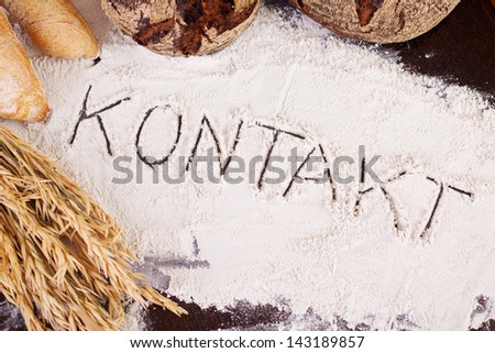 The word \'Kontakt\', written in flour on bakery table