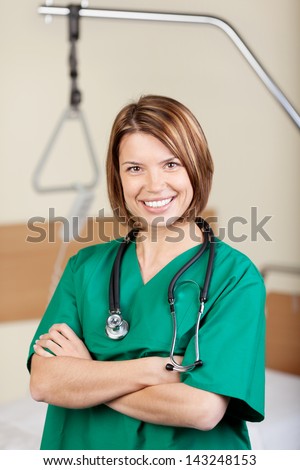 Profile portrait of a female doctor smiling with folded hands in the hospital.