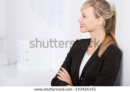 Businesswoman posing with arms crossed and leaning on the wall