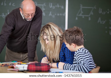 Teacher is checking on the work of his students