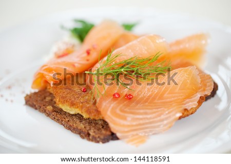 Closeup of cooked salmon slices on reibekuchen in plate at restaurant