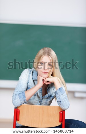 Serious student sits on a chair in classroom