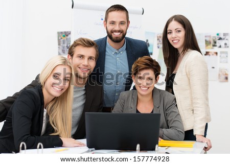 Successful business team of diverse young executives posing together smiling at the camera