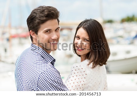 Cute couple smiling looking over their shoulders