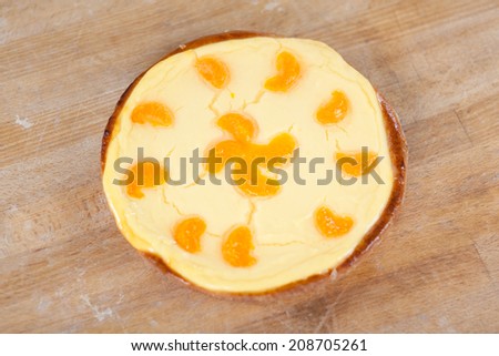 High angle view of orange pie on wooden table at bakery