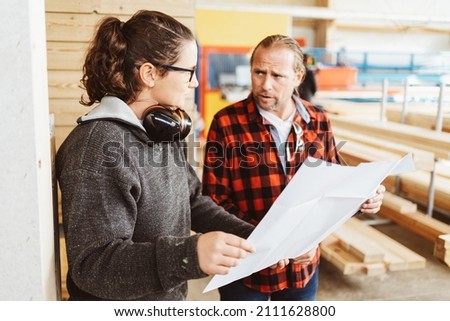 Co-workers at a woodworking factory discussing a blueprint looking at each other with concerned expressions in a production concept Foto d'archivio © 