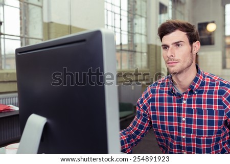 Close up Young Handsome Man in Checkered Shirt Using Computer Seriously.
