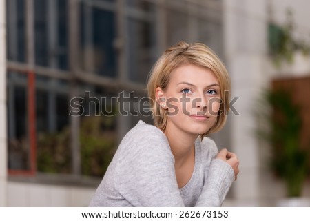 Close up Pretty Blond Woman Wearing Gray Long Sleeve Shirt with One Arm Crossing at the Chest Part, Looking at the Camera.