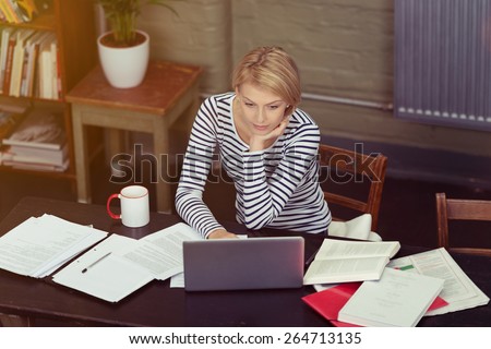 Attractive Businesswoman Surrounded By Paperwork As She Sits At Her ...