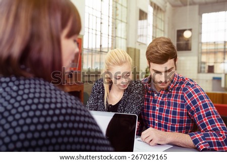 Young Couple Looking at the Project Proposal Document on the Table In Front of a Woman.