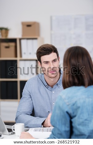 Close up Handsome Young Office Man Talking to his Female Co-worker While Sitting at his Worktable.