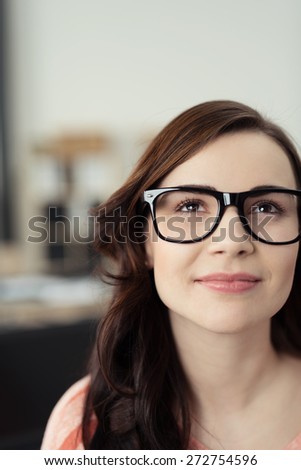 Close Up of Young Brunette Woman Wearing Eyeglasses with Black Frames Looking Up Optimistically, Daydreaming, or Thinking of Something Inspirational