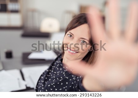 Close up Smiling Office Woman at her Worktable Trying to Reach the Camera with One Hand