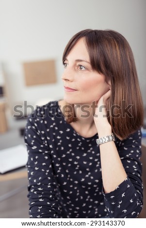 Close up Thoughtful Office Woman at her Desk Looking to the Left of the Frame While Leaning on her Hand.