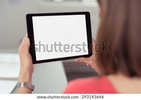 Woman sitting and using a black wireless tablet PC with white blank touch screen or interface, rear