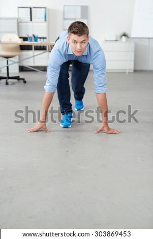 Good Looking Young Office Man in a Race Starting Position on the Floor with Copy Space, Looking at the Camera Seriously.