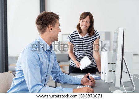 Two Happy Business People Talking About Company Plans at the Table Inside the Office