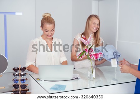 Cheerful Pretty Blond Girls at Cashier Counter Inside a Fashion Store.