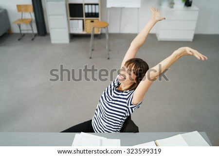 High Angle Shot of a Thoughtful Office Woman Sitting at her Desk, Stretching her Arms Up with Happy Facial Expression