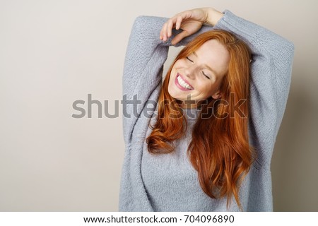 Image, Stock Photo Young beautiful red head looking serious to camera hipster woman .Trendy girl in summer T-shirt and black jeans .Serious and pensive female posing in the street near a brick wall.