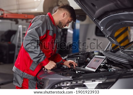 Similar – Image, Stock Photo Busy male mechanic repairing motorcycle seat in workshop