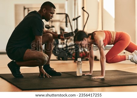 Similar – Foto Bild Starke ethnische Sportlerin trainiert an einem Trainingsgerät in einem modernen Fitnessstudio