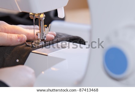 woman hands sewing on the stitching machine