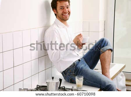 young man sitting in kitchen and have breakfast