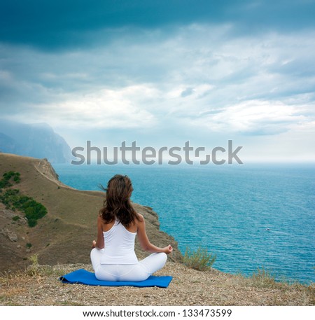 Woman Doing Yoga at the Sea and Mountains