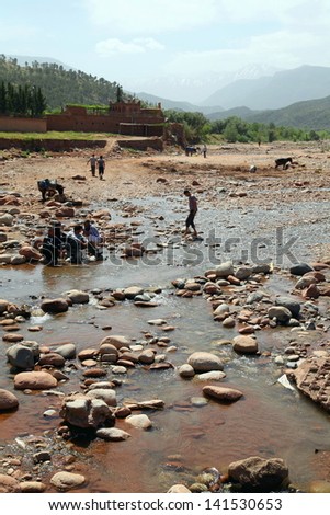 TNINE, MOROCCO-APRIL 29: Man working in the Ourika river in the village or Tnine, Morocco on April 29, 2013. Tnine is a small village famous for its weekly market.