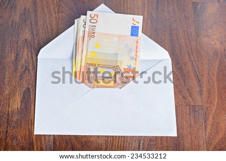 Open envelope with euro banknotes on table