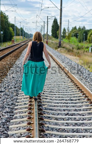 Trendy young women walking on the rail track