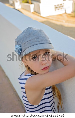 Cute little girl in denim cap in the city